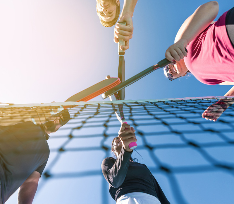 Pickleball paddles over net