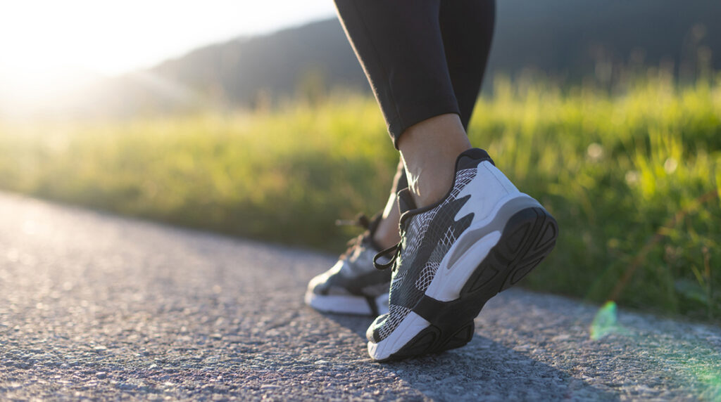 Person in sportswear walking showing gently used sneakers ideal for a global sneaker reuse program.