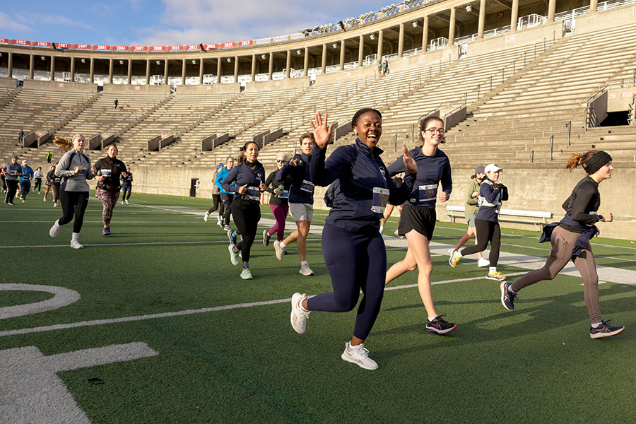 Girl waving in the stadium at the Cambridge Half Marathon race.