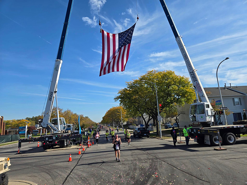 Detroit Free Press Marathon runners underneath the American flag put up by the Veterans Connected nonprofit.