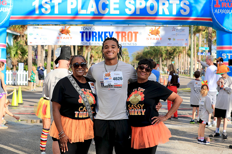 Three runners celebrating at the end of the UF Health Jacksonville Turkey Trot race.