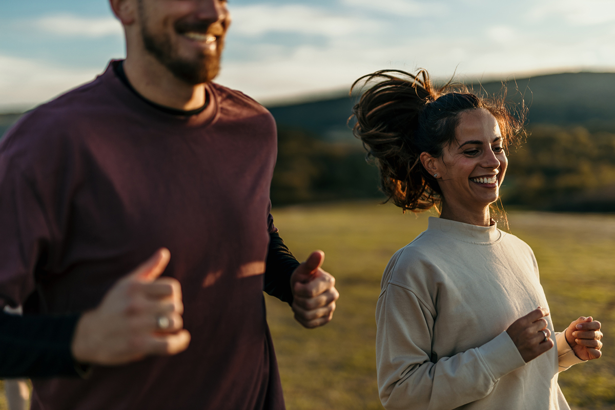 A couple running together in the fall.