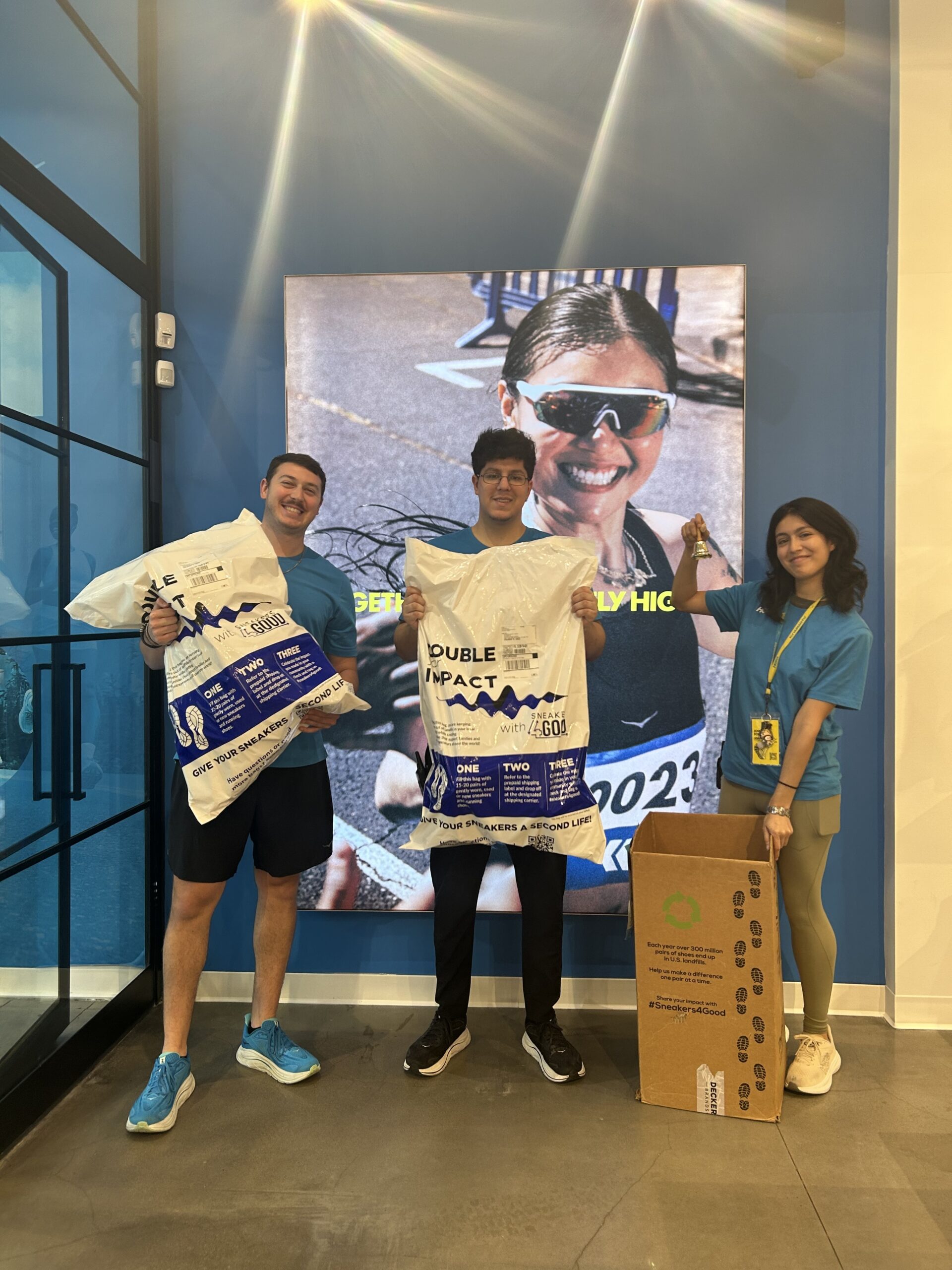 Diverse group holding shoe donations bags ready to send to Sneakers4Good.