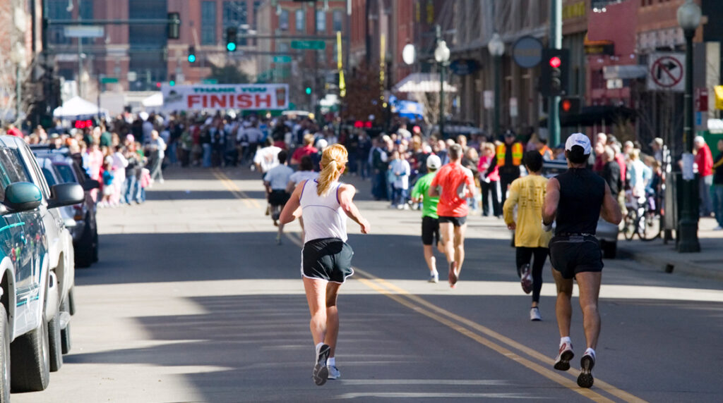 A group of half marathon runners approaches the finish line of a race.