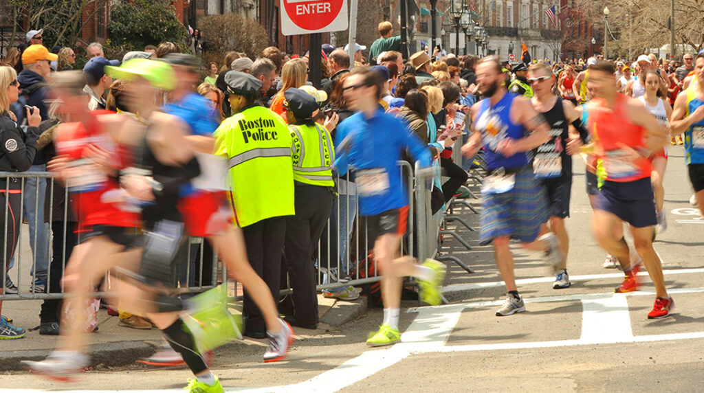 Boston Marathon runners pass police near Hereford Street, capturing the energy of one of the best marathons in the US.