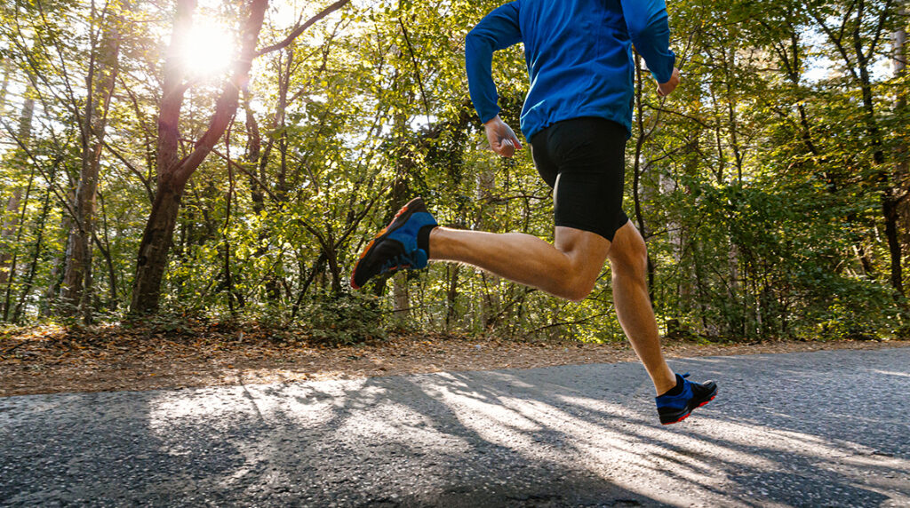 A male runner on a sunlit park road highlighting the simple things that inspire running through life and support a sustainable, active lifestyle.