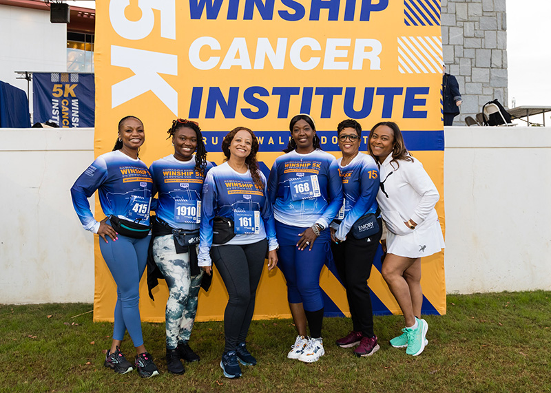 Emory Winship 5k runners smile while supporting sneaker recycling in Memphis.