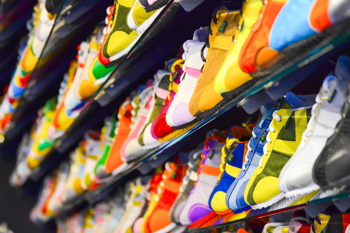 Colorful running shoes displayed on shelves in a shoe store.