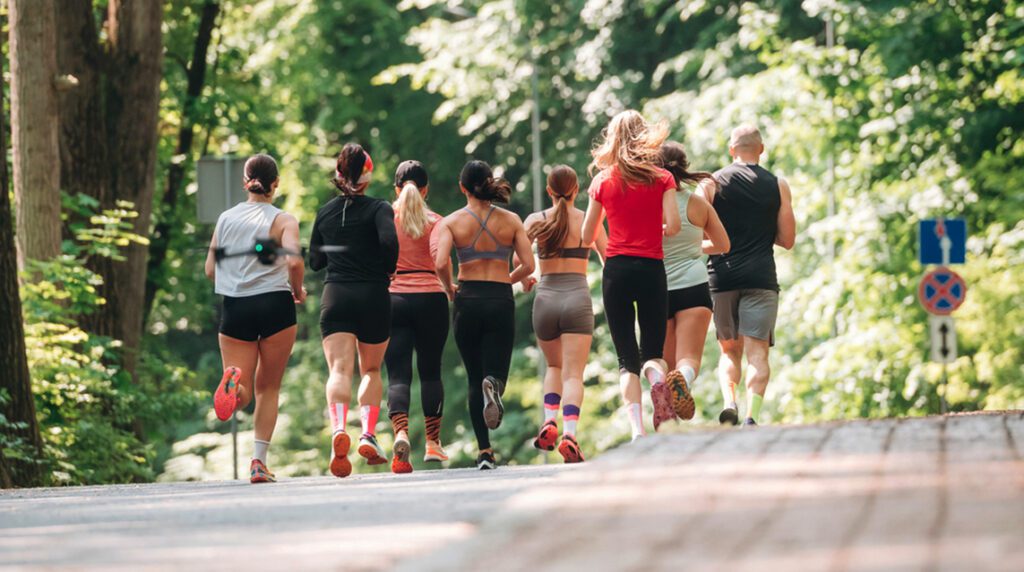 Runners logging weekly mileage together during a running club session in the park.